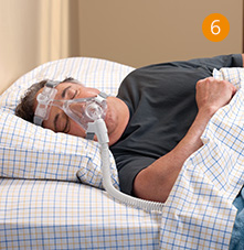 un hombre y una mujer acostados en la cama con una m&aacute;scara de ox&iacute;geno